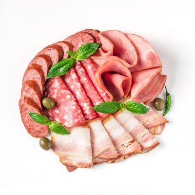 Antipasto set platter isolated on white background. Cold smoked meat plate with sausage, sliced ham,prosciutto,bacon,olives,basil. Copy space. Top view or flat lay.Isolated on white with clipping path